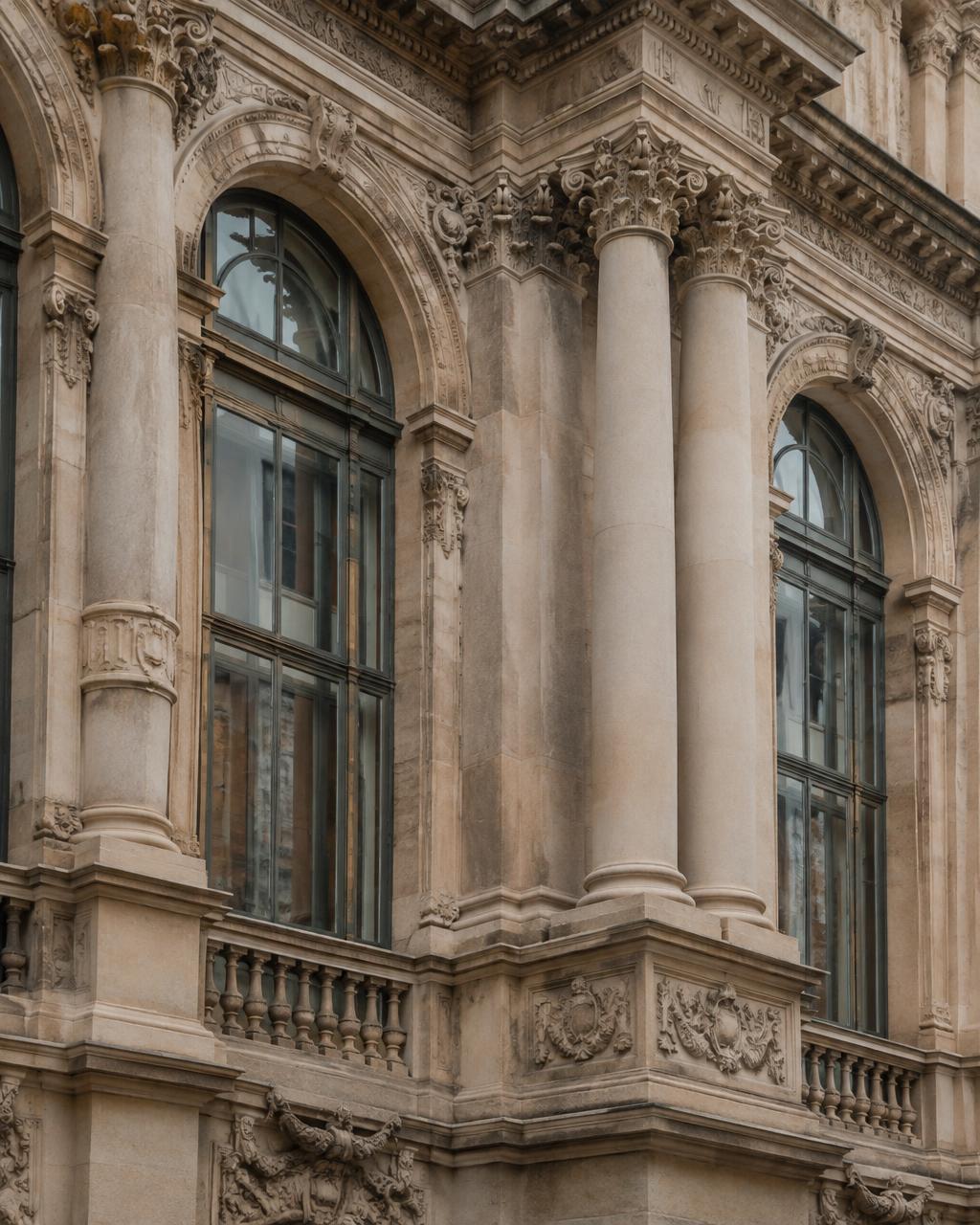 Carved stone façade with arched windows and columns